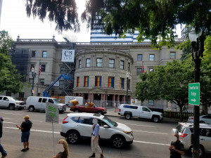 Protest at city hall in 2019 (Sam Bouman) People gathered at a protest across the street from Portland city hall with Pride flags in the windows.