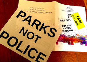 handouts from forum: sign "Parks not Police"; sticker "care not cops"
