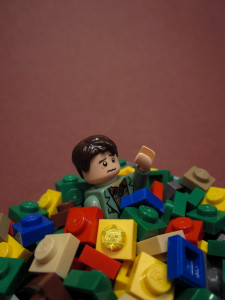 The Self Help Logo is pasted onto an image of a toy man covered by legos as if drowning in them